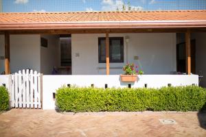 ein Haus mit einem weißen Zaun und einem Blumentopf in der Unterkunft Residence Arco delle Rose in Agropoli