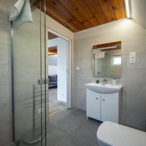 uma casa de banho com um chuveiro, um lavatório e um WC. em Horizont idéző ParkMotel em Orfű