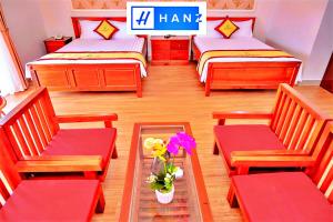 Cette chambre comprend 4 lits et une table fleurie. dans l'établissement Bao Long Hotel, à Hô-Chi-Minh-Ville