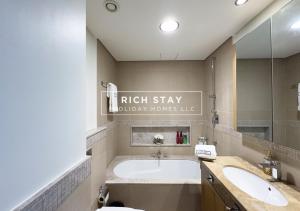 a bathroom with a tub and a sink at Superb 1BR at Burj Vista In Downtown Dubai in Dubai