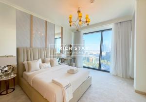 a bedroom with a large bed with a large window at Superb 1BR at Burj Vista In Downtown Dubai in Dubai