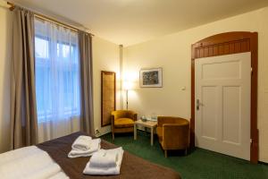 a hotel room with a bed and a desk and a window at Pension Hubert in Raspenava