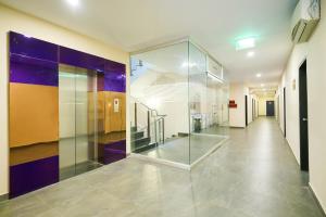 a hallway with a glass elevator in a building at Mookkannoor Tourist Home in Angamali