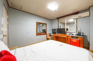 J Motel في يوسو: غرفة نوم مع سرير ومكتب مع جهاز كمبيوتر