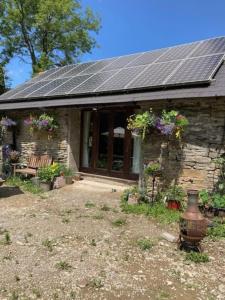 a house with a solar roof with flowers on it at Yr Ysgubor Converted milking parlour in Llandysul