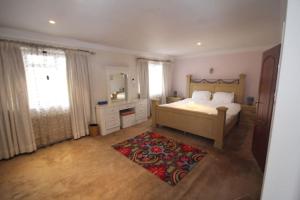 een slaapkamer met een bed, een spiegel en een tapijt bij High Gable House -Four Bedrooms in Hillingdon