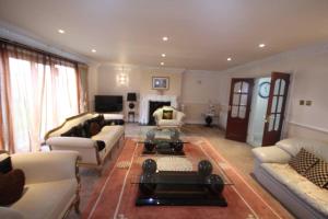 a large living room with couches and a coffee table at High Gable House -Four Bedrooms in Hillingdon