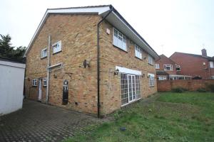 a brick building with a gate and a garage at High Gable House -Four Bedrooms in Hillingdon