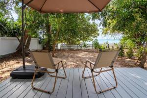 サムイ島にあるBrand New Beachfront & Secluded Tiny Houseのデッキに座る椅子2脚(傘下)