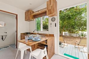 サムイ島にあるBrand New Beachfront & Secluded Tiny Houseのキッチン(木製カウンター、テーブル、椅子付)