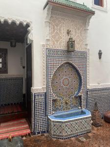uma parede de azulejos azuis e brancos com uma banheira em Charmant Ryad à 1mn de BAB BOUJLOUD DAR SERRAJ em Fez