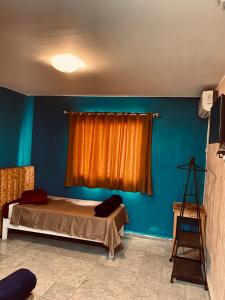 a bedroom with a bed and an orange curtain at Hotel Dar Ali in Tunis