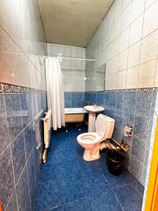 a bathroom with a toilet and a sink and a tub at Гостиничный комплекс Bal-Meyir in Almaty
