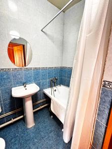 a bathroom with a sink and a tub and a toilet and a mirror at Гостиничный комплекс Bal-Meyir in Almaty