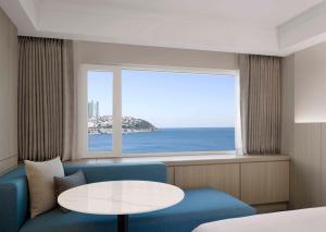 a room with a couch and a table and a window at The Westin Josun Busan in Busan