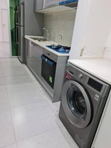 a kitchen with a washing machine and a stove at Your home in central Luanda in Luanda