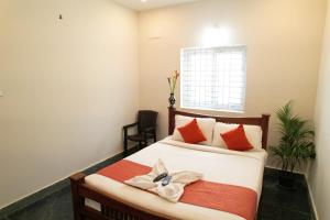 a bedroom with a bed and a window at Unique ajvi Resorts inn Yercaud in Yercaud