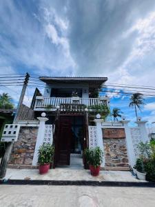 un edificio con puerta y macetas delante en The White Palace Koh Sdach, en Kaoh Sdach