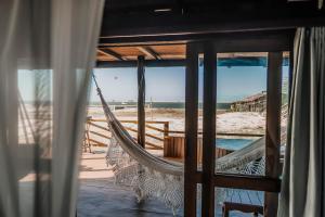 uma rede de descanso numa praia com vista para o oceano em Vila Vento em Atins