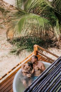 Ein Mann und eine Frau in einer Badewanne am Strand in der Unterkunft Vila Vento in Atins
