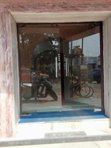 a reflection of two men in a window at Hotel Savera, agra in Agra