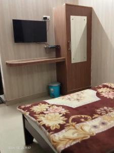 a room with a bed and a tv on a wall at Hotel Savera, agra in Agra