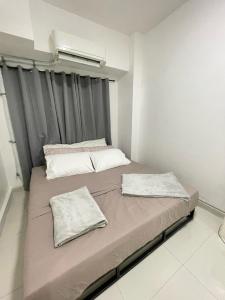 twee bedden in een kleine kamer met een raam bij Signa Designer Residences in Manilla