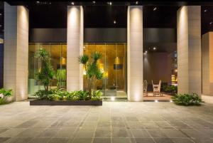 een lobby van een gebouw met palmbomen en planten bij Signa Designer Residences in Manilla