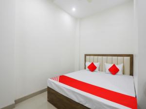 a bedroom with a bed with red and white pillows at OYO Flagship Hotel Rahul Service Appartment 2 in Nagpur