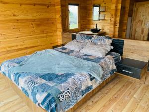 a bedroom with a bed in a log cabin at CHALET EN BOIS PRIVATIF ST POURCAIN SUR SIOULE in Bransat
