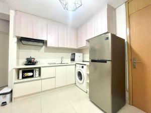 een keuken met een koelkast en een wasmachine bij Signa Designer Residences in Manilla