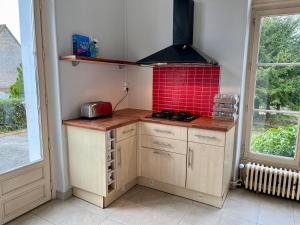 Il comprend une petite cuisine dotée d'une cuisinière et de carrelage rouge. dans l'établissement Superbe Maison de maître 10 chambres 300 m2 Caen, à Bretteville-sur-Odon