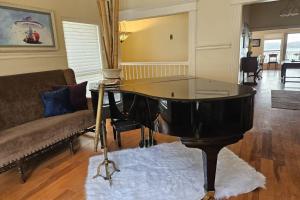 un pianoforte nero in un soggiorno con divano di Mountain Trail Retreat ad Austin