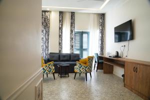 uma sala de estar com um sofá e cadeiras e uma secretária em HOTEL GRP INN CITY HOME em Pithorāgarh