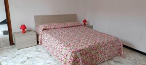 Luna Rossa da Nadia في ليفانتو: غرفة نوم مع سرير وطاولتين مع مصابيح حمراء