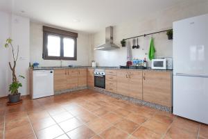 uma cozinha com armários de madeira e um frigorífico branco em CASA GALEX em Sarrión