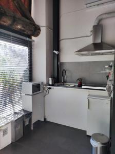 a kitchen with white cabinets and a sink and a window at Anna e Gaetano in Misterbianco