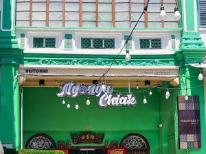 a green building with a sign for a chinese restaurant at Peranakan Suites Georgetown in George Town