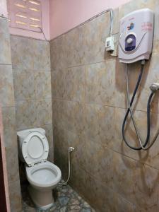 ein Badezimmer mit einem WC und einem Seifenspender an der Wand in der Unterkunft Vang Vieng Chanthala Hotel 1 in Vang Vieng