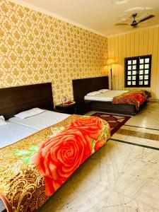 a bedroom with two beds and a red rose blanket at Divine palace in Vrindāvan