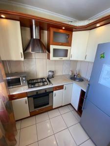 a small kitchen with a stove and a sink at RIO in Petropavlovsk
