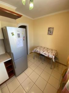 a kitchen with a refrigerator and a table in it at RIO in Petropavlovsk