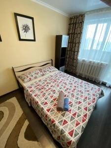 un dormitorio con una cama con un animal de peluche en RIO en Petropavlovsk