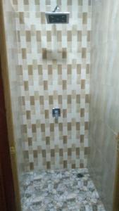 a bathroom with a shower with a checkerboard wall at Senja Bay Resort in Perhentian Islands