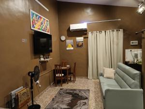 Studio Teratak Alisha Permatang Pauh في Permatang Pauh: غرفة معيشة مع أريكة وطاولة