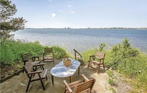 Una mesa y sillas con vista al agua. en Three-Bedroom Holiday Home In Stege, en Stege