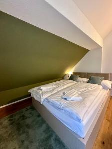 un letto in una camera con parete verde di WELCOME HOTEL - Hellbühl a Hellbühl