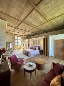 ein großes Schlafzimmer mit einem Bett und ein Wohnzimmer in der Unterkunft CHATEAU DE LA CITARDIERE in Mervent