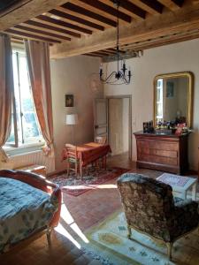 a bedroom with a bed and a desk and a mirror at Maison de Noble Nicolas in Avallon