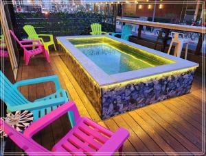 a pool sitting on a deck with colorful chairs at Dream Beach Hotel And Spa in Tel Aviv